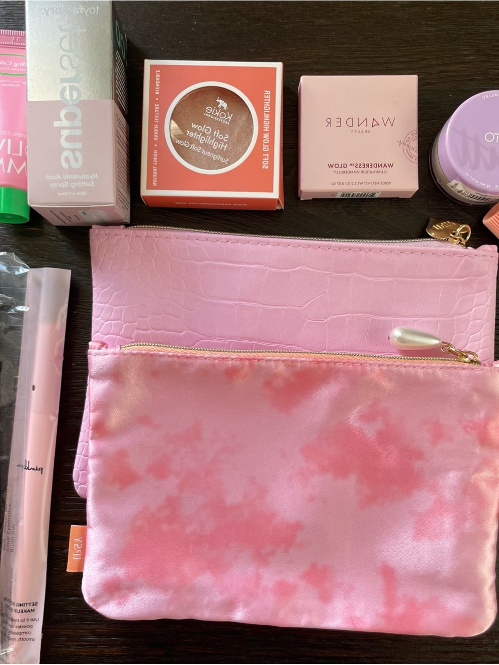 ipsy Pink Tie-Dye and Croc Texture Makeup Pouches with a variety of makeup